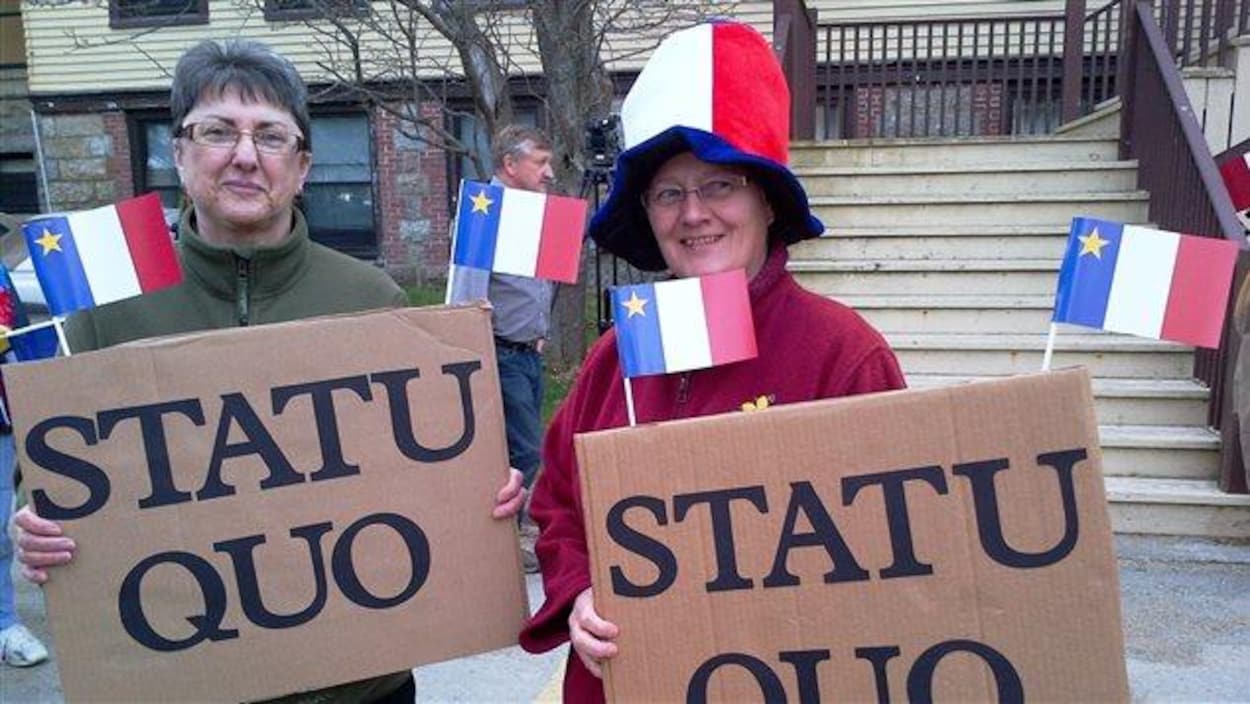 Deux manifestantes à Pointe-de-l'Église réclament le statu quo pour les circonscriptions acadiennes de la Nouvelle-Écosse.