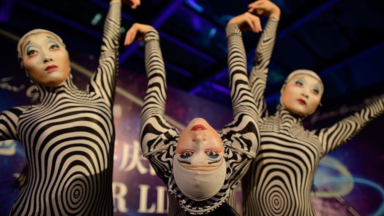 Trois femmes posent en costume noir et blanc.