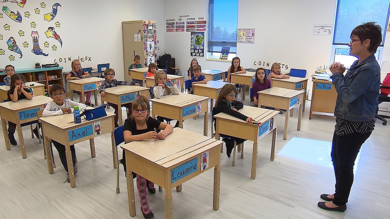 Quinze élèves écoutent leur professeur.