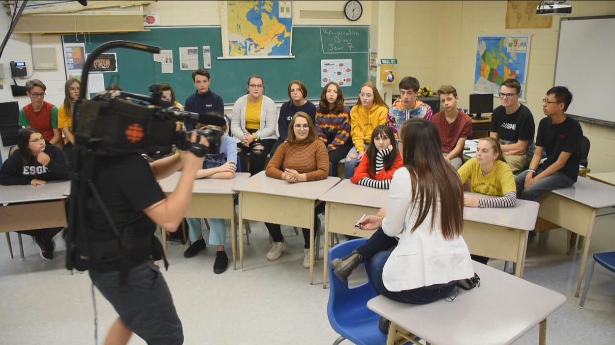 Des élèves dans une classe où un tournage est en cours.