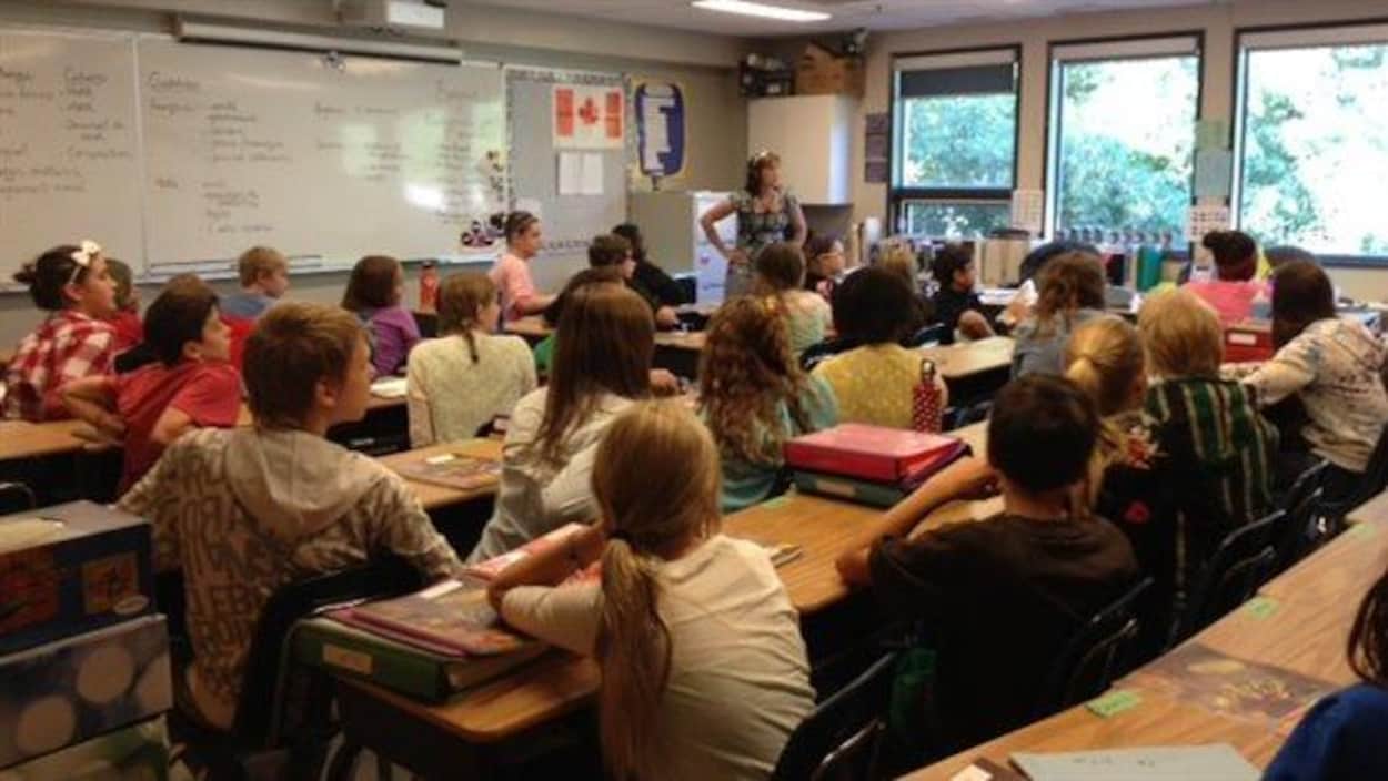 Des élèves du pavillon élémentaire de l'École canadienne-française de Saskatoon écoutent leur enseignante en classe. Des élèves du pavillon élémentaire de l'École canadienne-française de Saskatoon écoutent leur enseignante en classe.