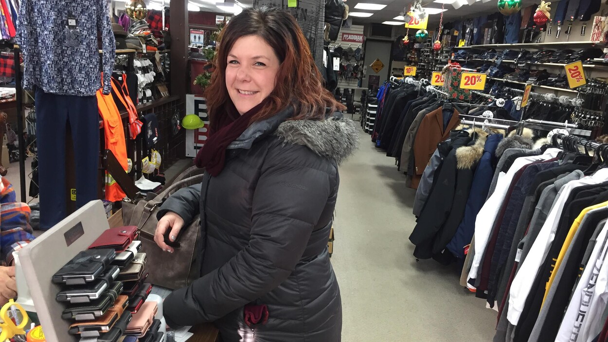 Une femme dans un magasin de vêtements pour hommes.