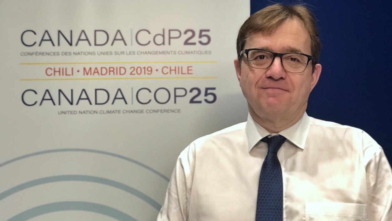 Jonathan Wilkinson, devant une affiche de la COP25.