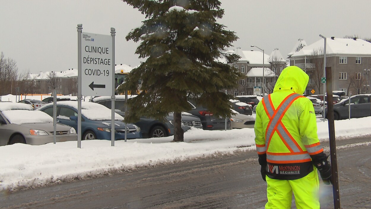 Un agent de sécurité près de l'entrée d'une clinique de dépistage au volant de la COVID-19 à Lévis.