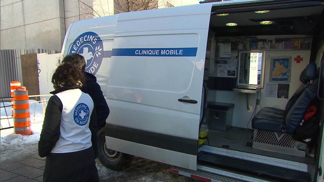 Des bénévoles de Médecins du monde Canada discutent à côté de la camionnette qui fait office de clinique mobile.