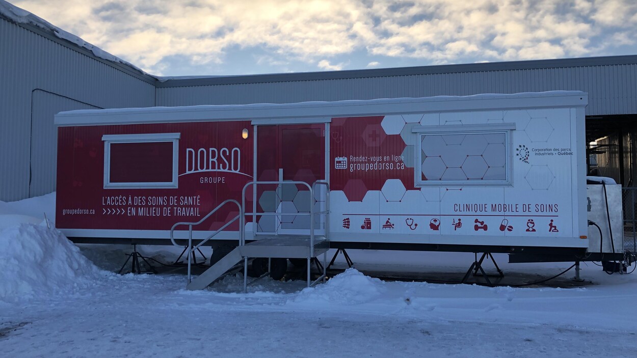 Une clinique mobile devant une usine.