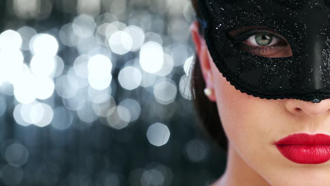 Image tirée du site web du club privé d'effeuillage Regina 151. Gros plan sur le visage d'une femme portant un loup et du rouge à lèvres rouge. L'arrière-plan est flou et composé de billes lumineuses. Image tirée du site web du club privé d'effeuillage Regina 151. Gros plan sur le visage d'une femme portant un loup et du rouge à lèvres rouge. L'arrière-plan est flou et composé de billes lumineuses.