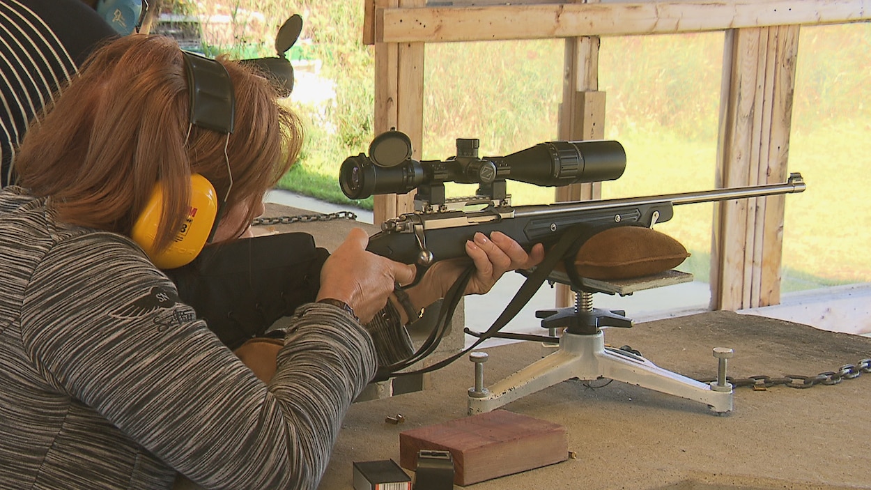 Femme qui vise avec une arme à feu