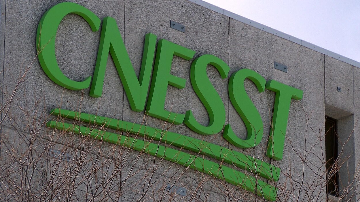 Plan rapproché sur le logo ornant le siège social de la CNESST à Québec. Les lettres C-N-E-S-S-T sont peintes en vert.