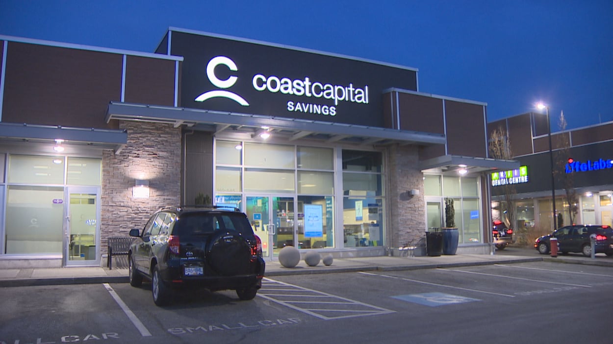 Plan large d'une des succursales de Coast Capital, vue de l'extérieur, en soirée, avec une voiture stationnée devant.