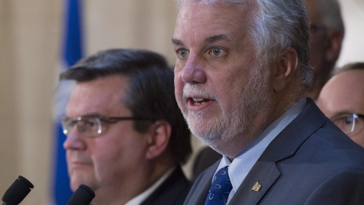 Le premier ministre Philippe Couillard, accompagné ici du maire de Montréal Denis Coderre, présente son projet de loi 122.