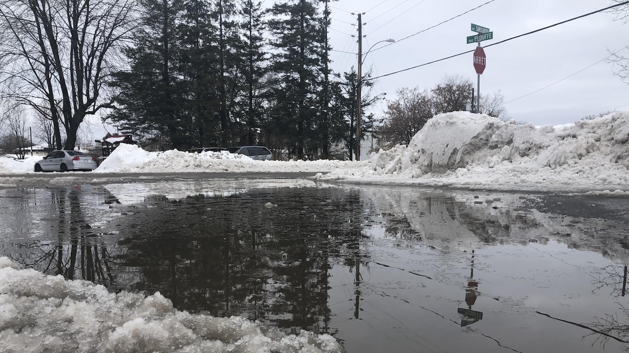 Une grande flaque d'eau sur la chaussée en hiver.