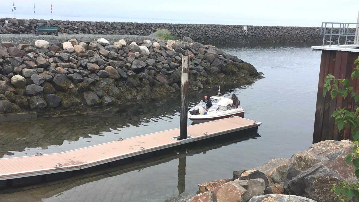 Un petit bateau s'approche du quai des pêcheurs à Sept-Îles. Un petit bateau s'approche du quai des pêcheurs à Sept-Îles.