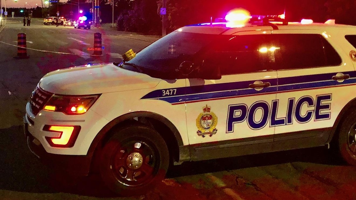 Une voiture de police bloque l'intersection.