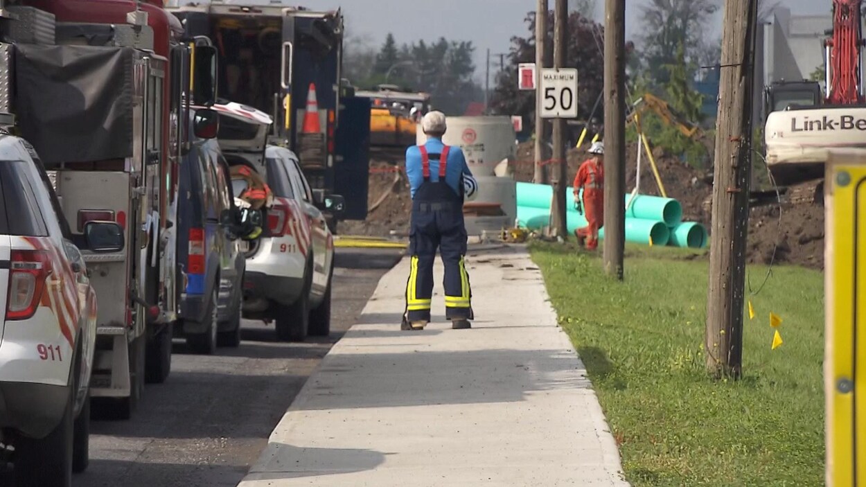 Un travailleur observe le site où des travaux d'excavation ont provoqué la fuite de gaz.