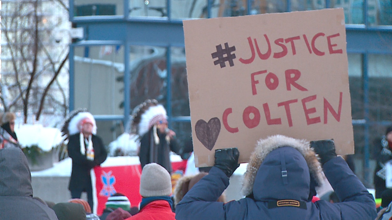 Un manifestant de dos tient une pancarte sur laquelle il est écrit « justice pour Colten ». Un manifestant de dos tient une pancarte sur laquelle il est écrit « justice pour Colten ».