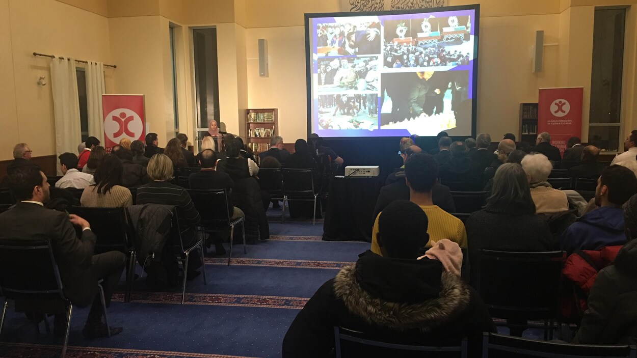 Des gens assis sur des chaises qui regardent une présentation vidéo