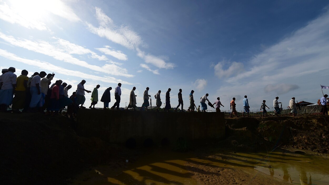 Des Rohingyas marchent l'un derrière l'autre pour fuir le Myanmar.