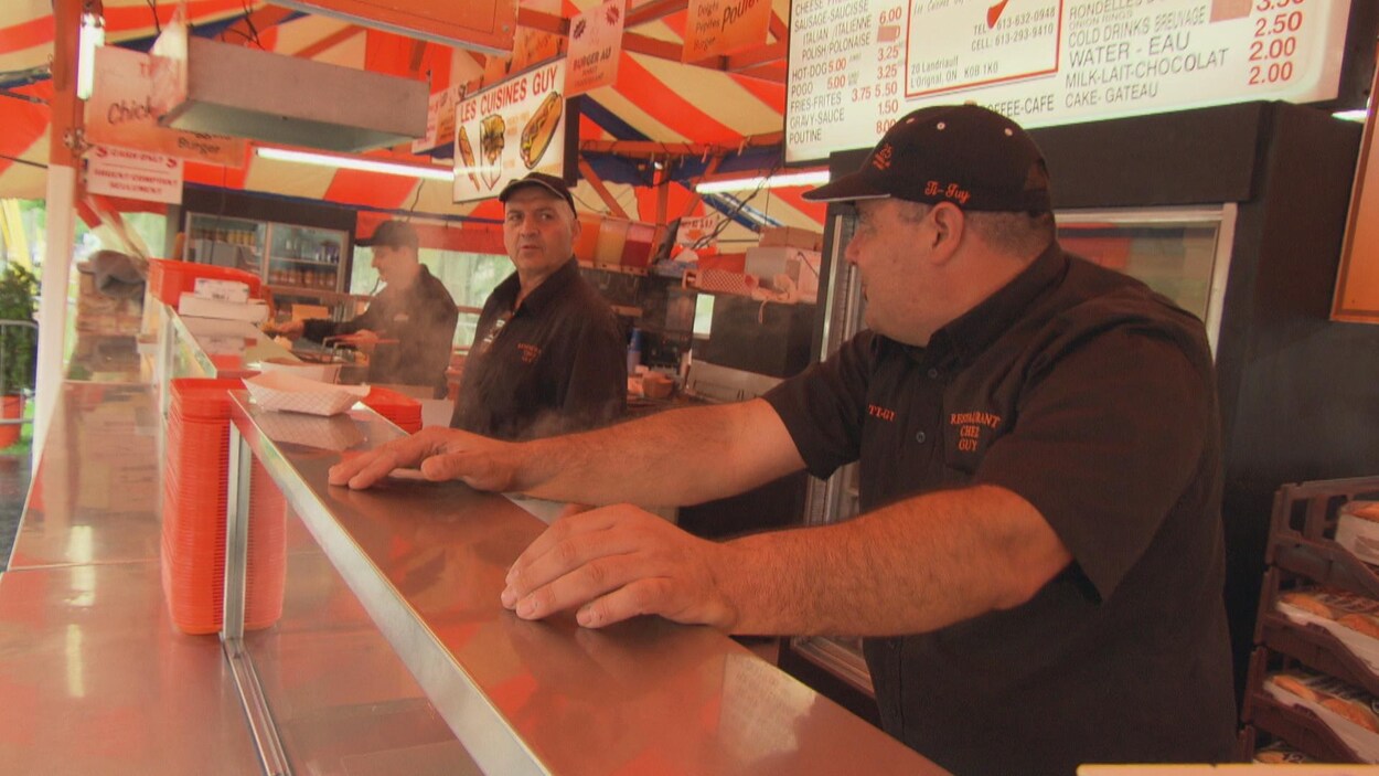 Trois cuisiniers discutent dans une cantine.