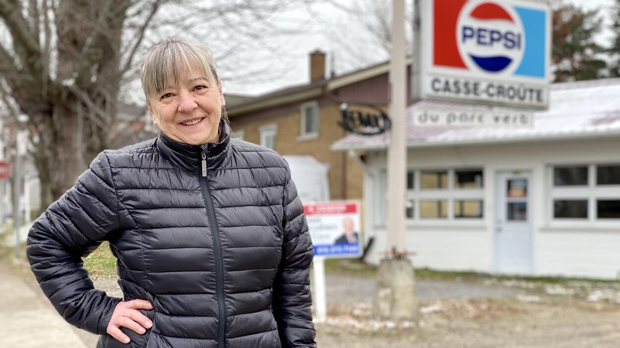 Une femme devant son casse-croûte à vendre.