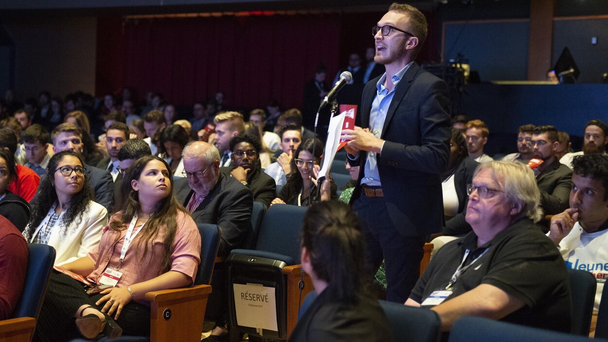 Un militant au micro lors d'un congrès de la Commission-jeunesse du Parti libéral du Québec