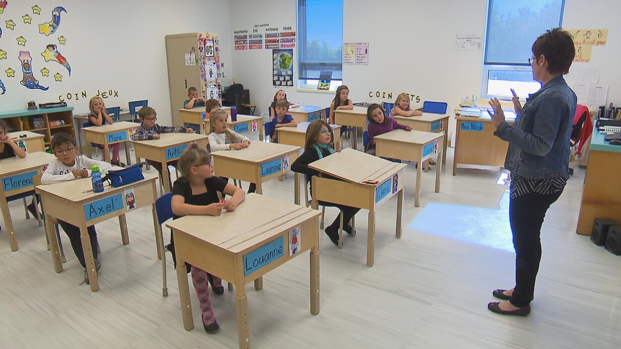 Une enseignante devant les élèves dans une classe de primaire.