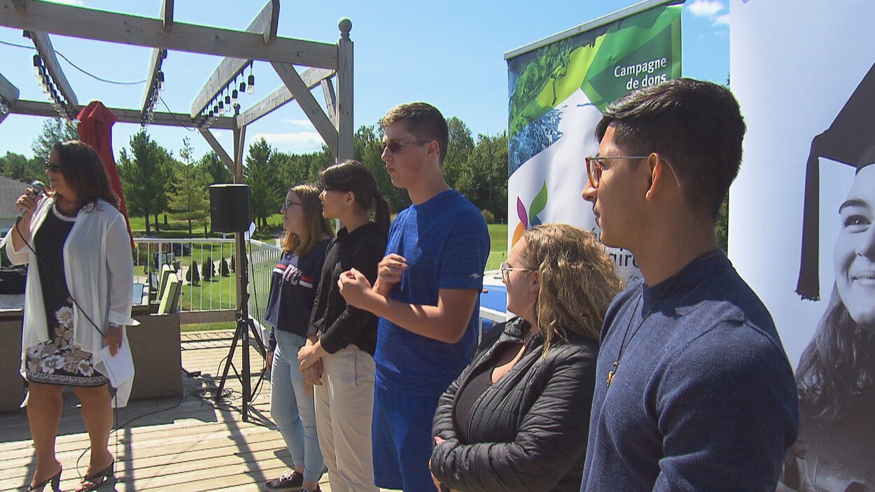 Des jeunes sont côte-à-côte sur une scène.