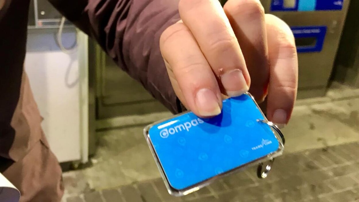 Une main tenant une petite carte bleue.