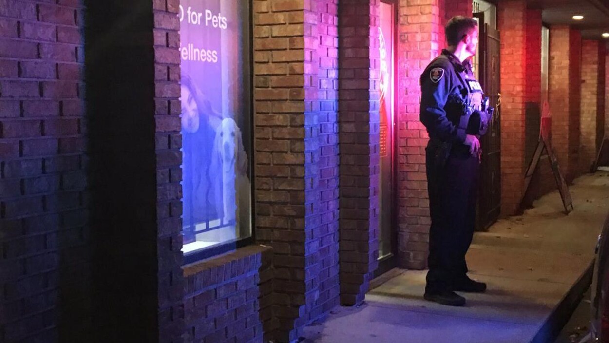 Un policier est devant un magasin la nuit Un policier est devant un magasin la nuit