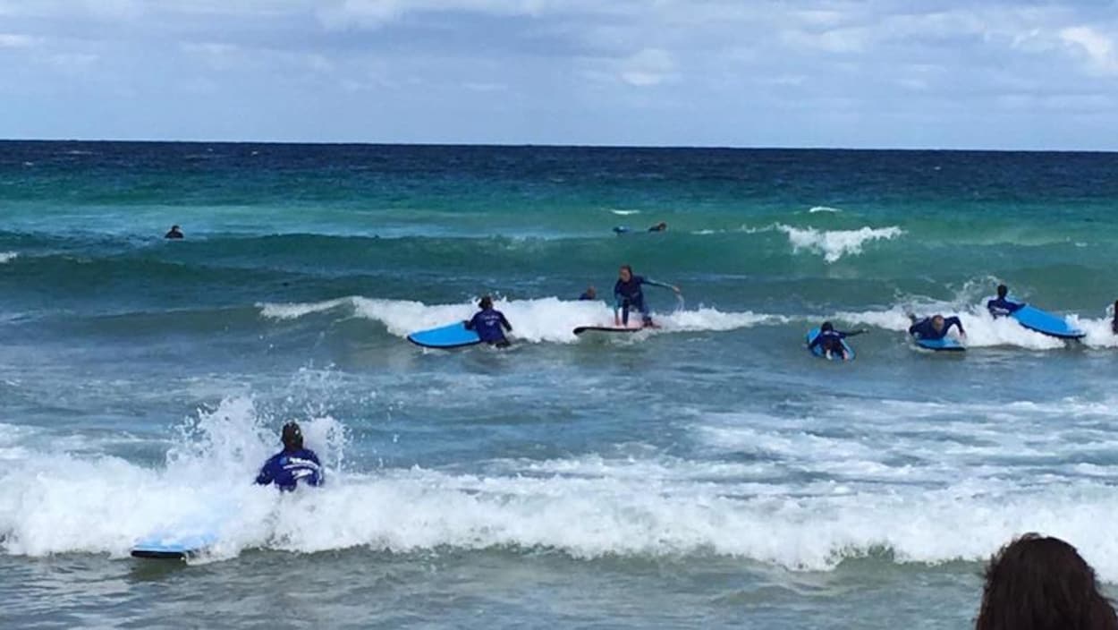 Des jeunes font du surf dans l'océan.