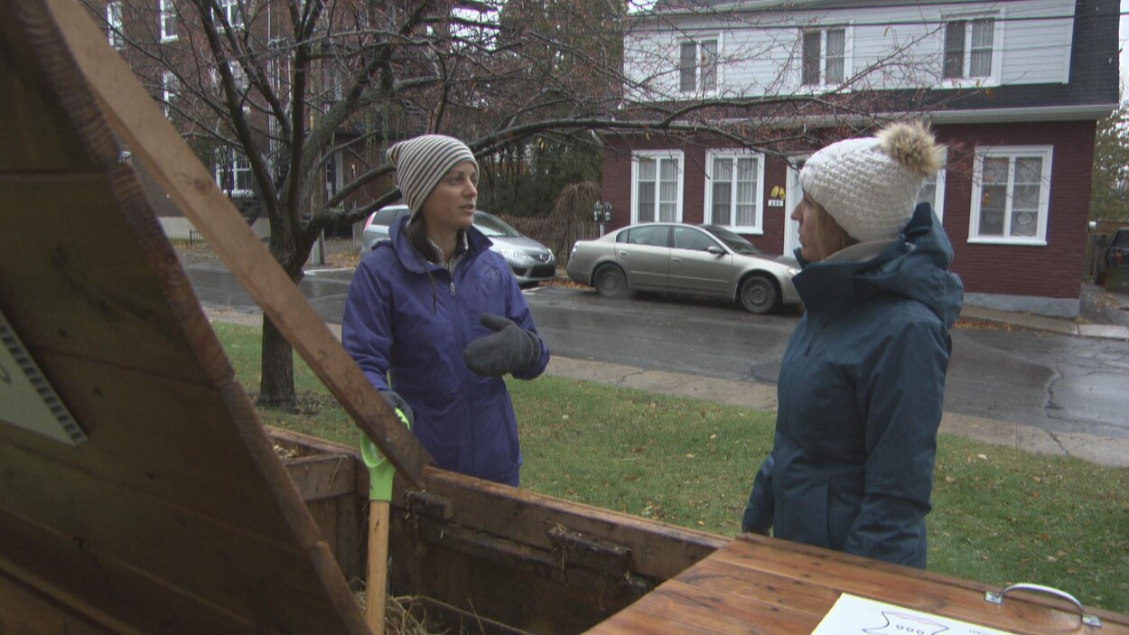 Joëlle Carle discute avec la journaliste Claudie Simard à côté d'un bac de compost communautaire.