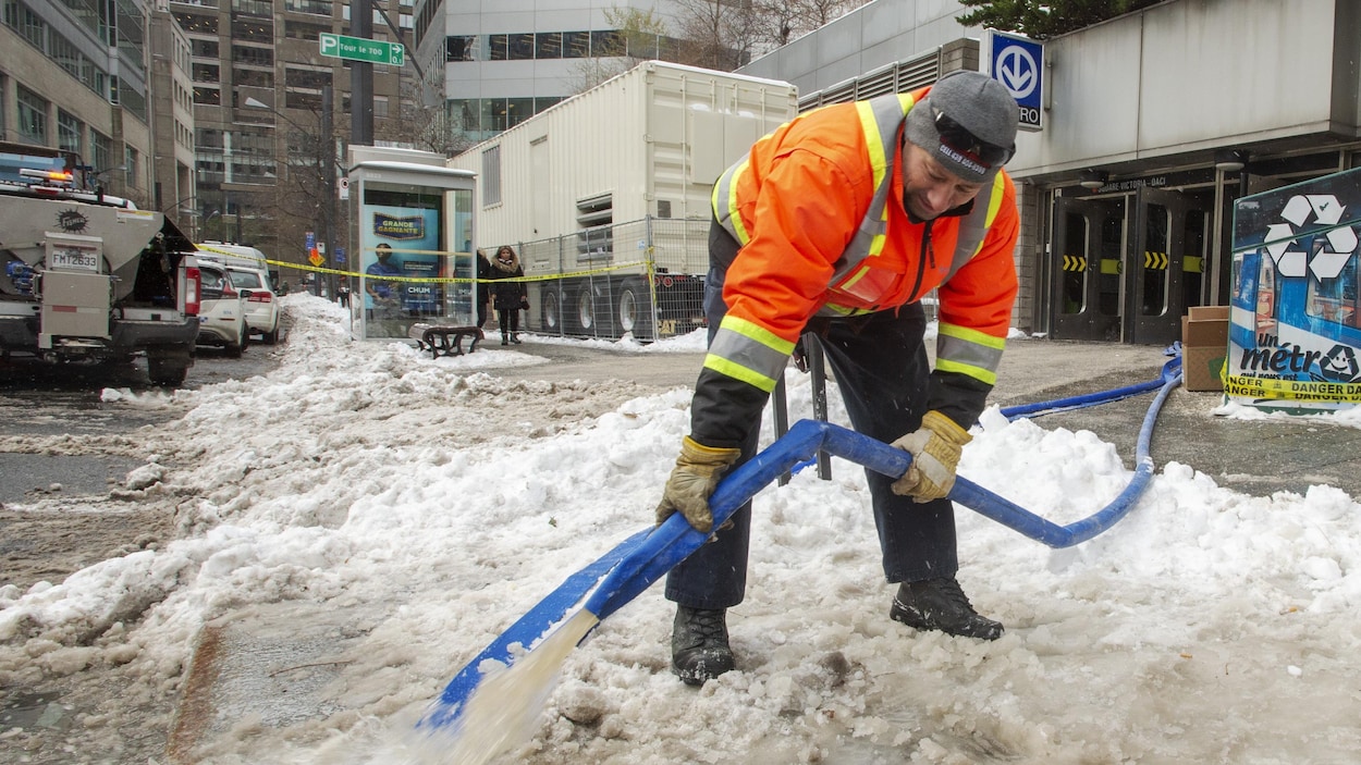 Un employé évacue l'eau qui a inondé une station de métro.