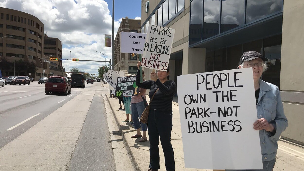 Des manifestants brandissent des pancartes, telles que « Le parc appartient aux gens, pas aux entreprises ». Des manifestants brandissent des pancartes, telles que « Le parc appartient aux gens, pas aux entreprises ».