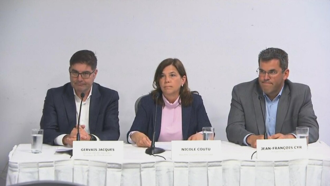 Les trois personnes assises à une table
