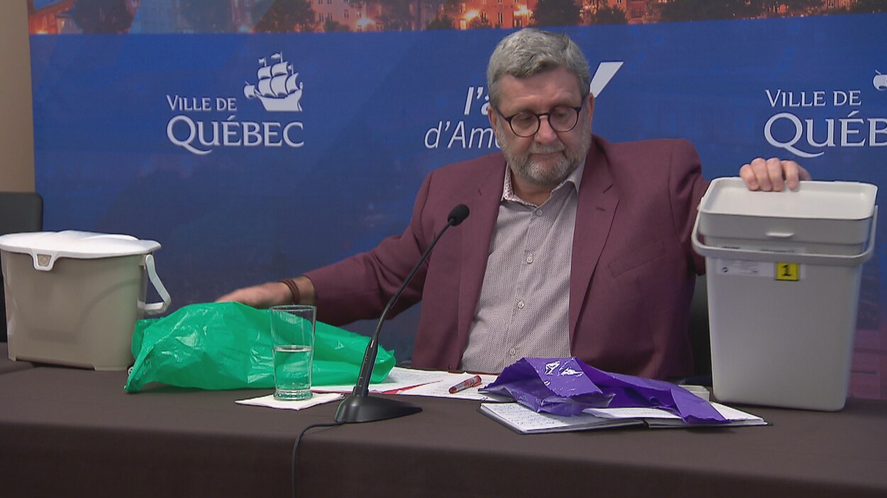 Régis Labeaume présente ici les deux sacs testés dans le cadre d'un projet-pilote.