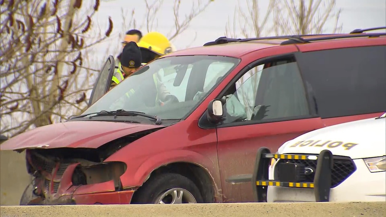 Des policiers et pompiers examinent une fourgonnette à l'avant violemment accidenté.