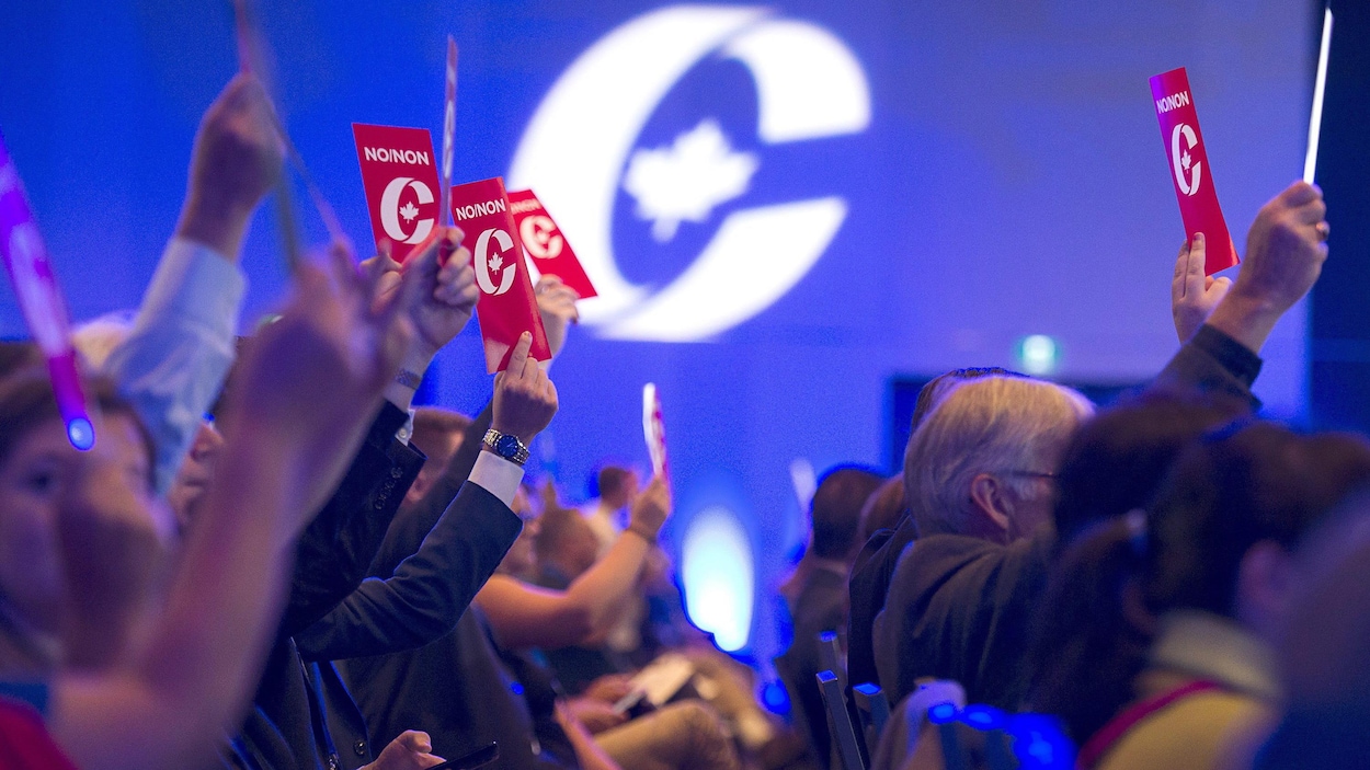 Des partisans conservateurs assis brandissant des cartons