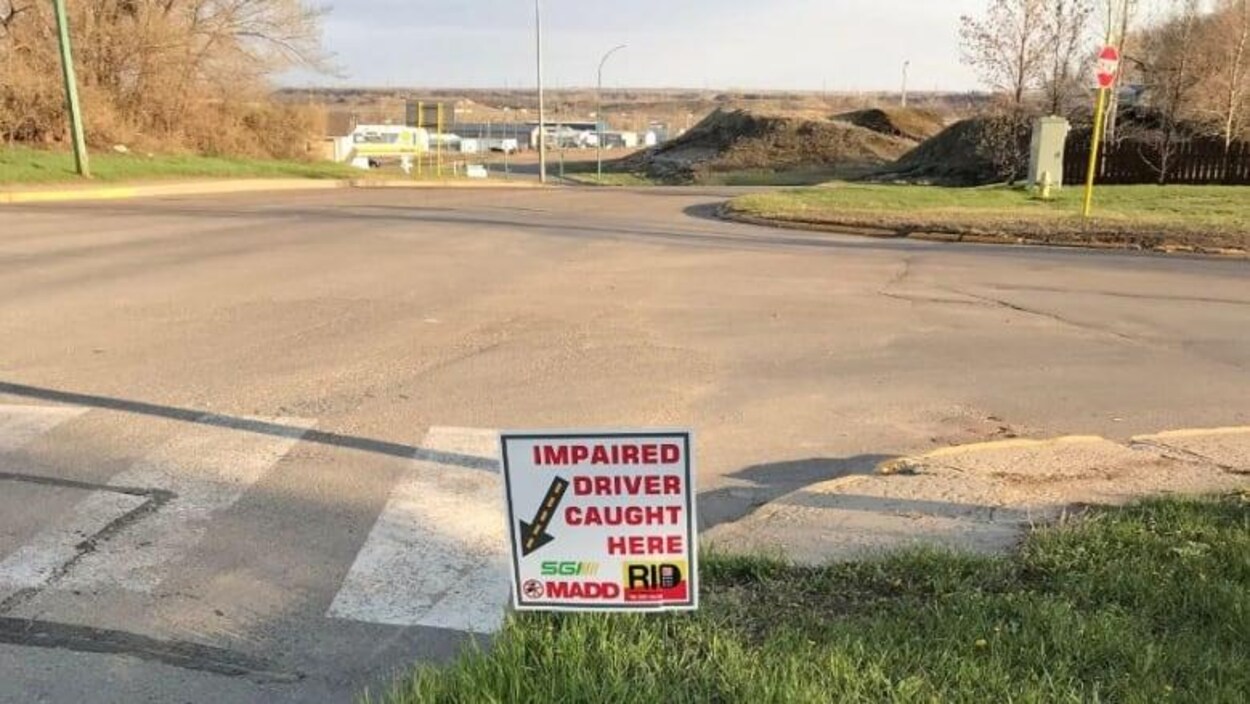 Un des écriteaux installés au ras du gazon près d’une intersection.