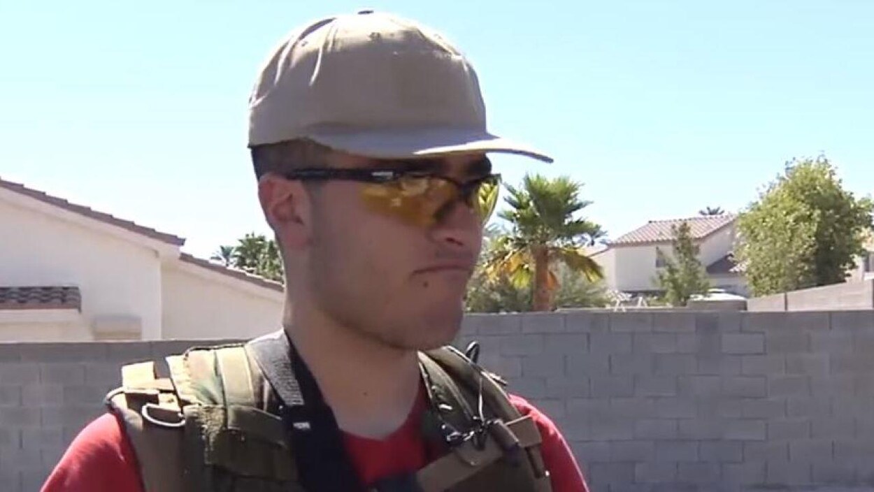 Un jeune homme portant une casquette et une veste pare-balles.
