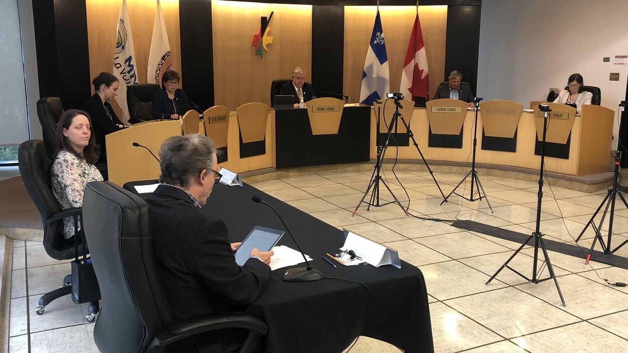 Des élus sont réunis dans la salle du conseil. Ils occupent une chaise sur deux pour respecter la distanciation physique.