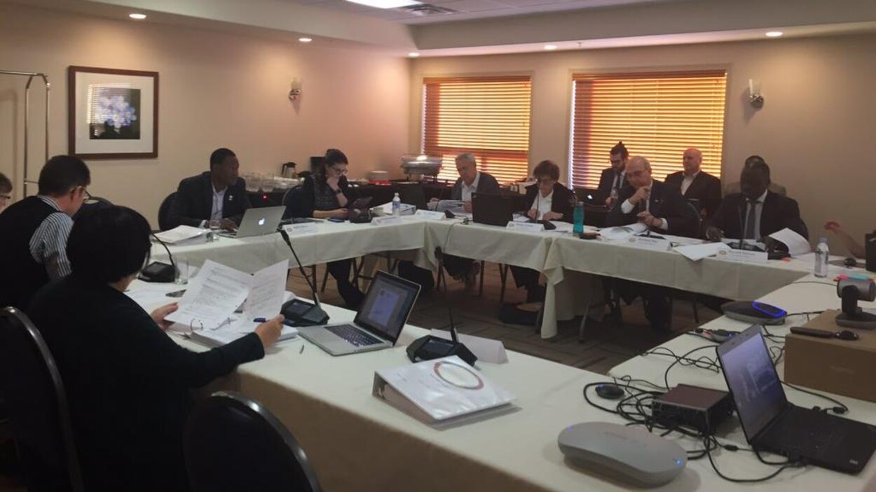 Les membres du conseil d'administration du CSF sont assis autour des tables formant un carré. Ils examinent des documents au cours de la réunion du conseil à Saskatoon.