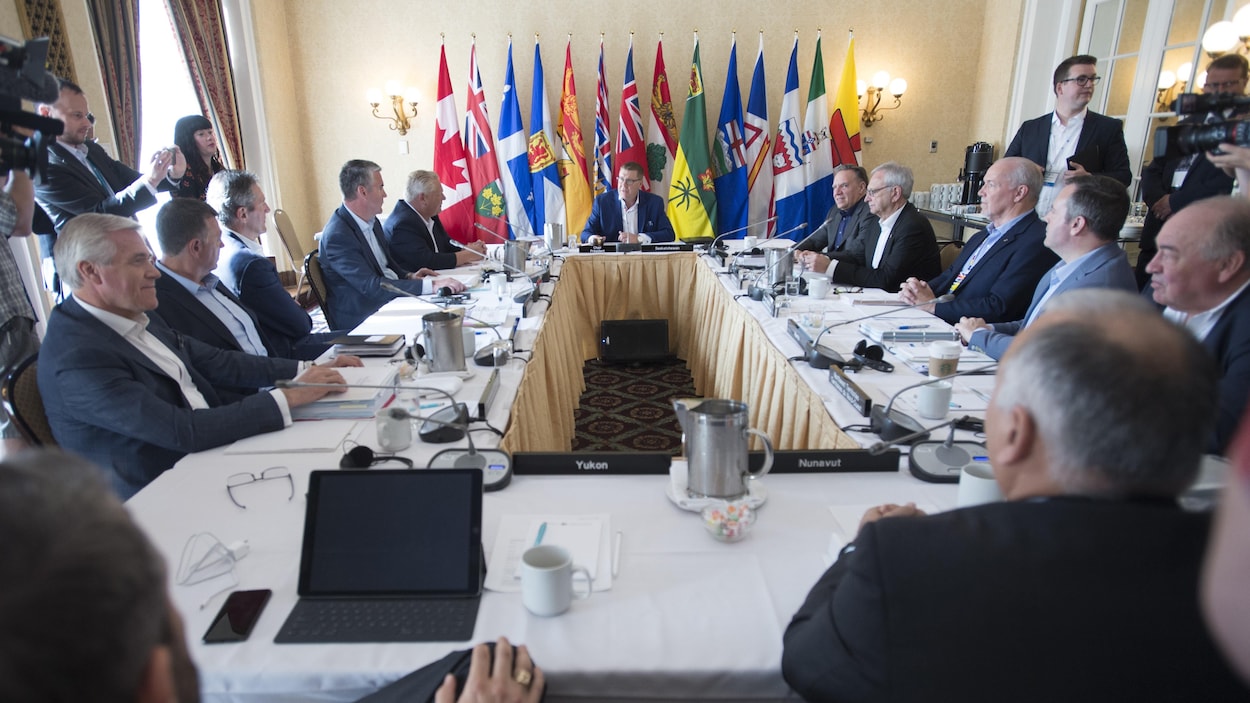 Tous les dirigeants provinciaux et territoriaux du Canada réunis autour d'une table au Conseil de la fédération à Saskatoon.