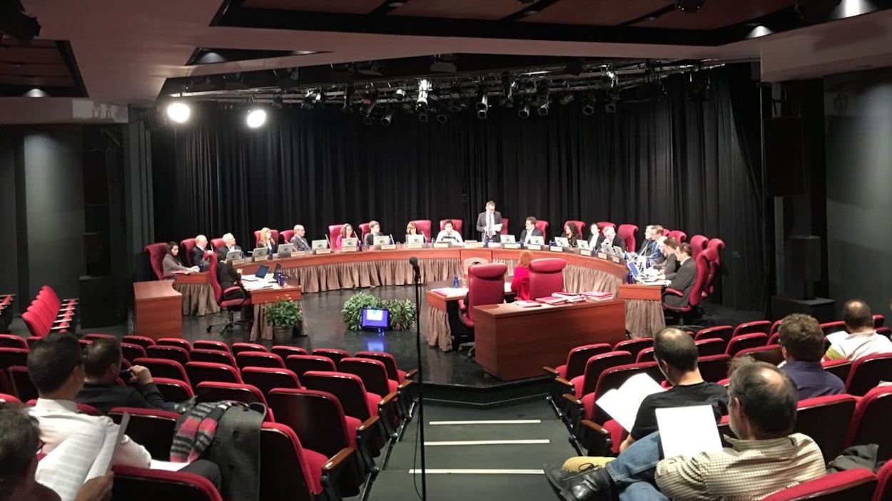 Les élus assis autour de la table du conseil municipal devant des membres du public et de la presse. Les élus assis autour de la table du conseil municipal devant des membres du public et de la presse.