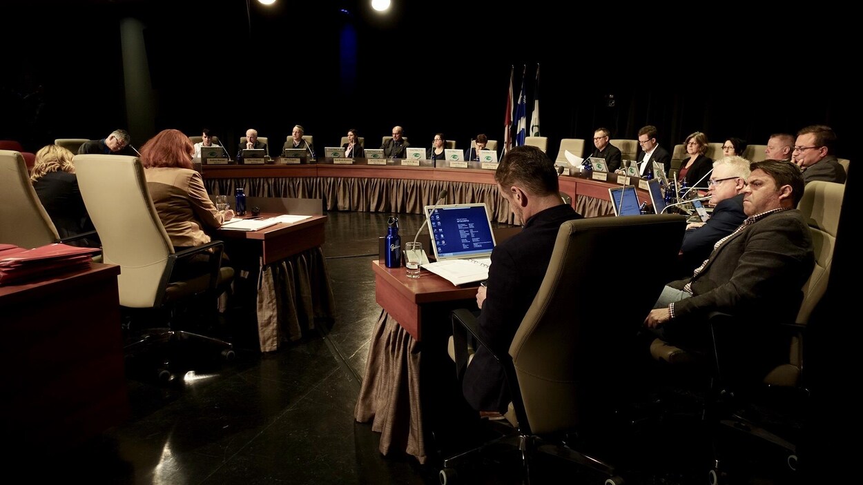 Des politiciens assis autour d'une grande table en forme de demi-cercle.