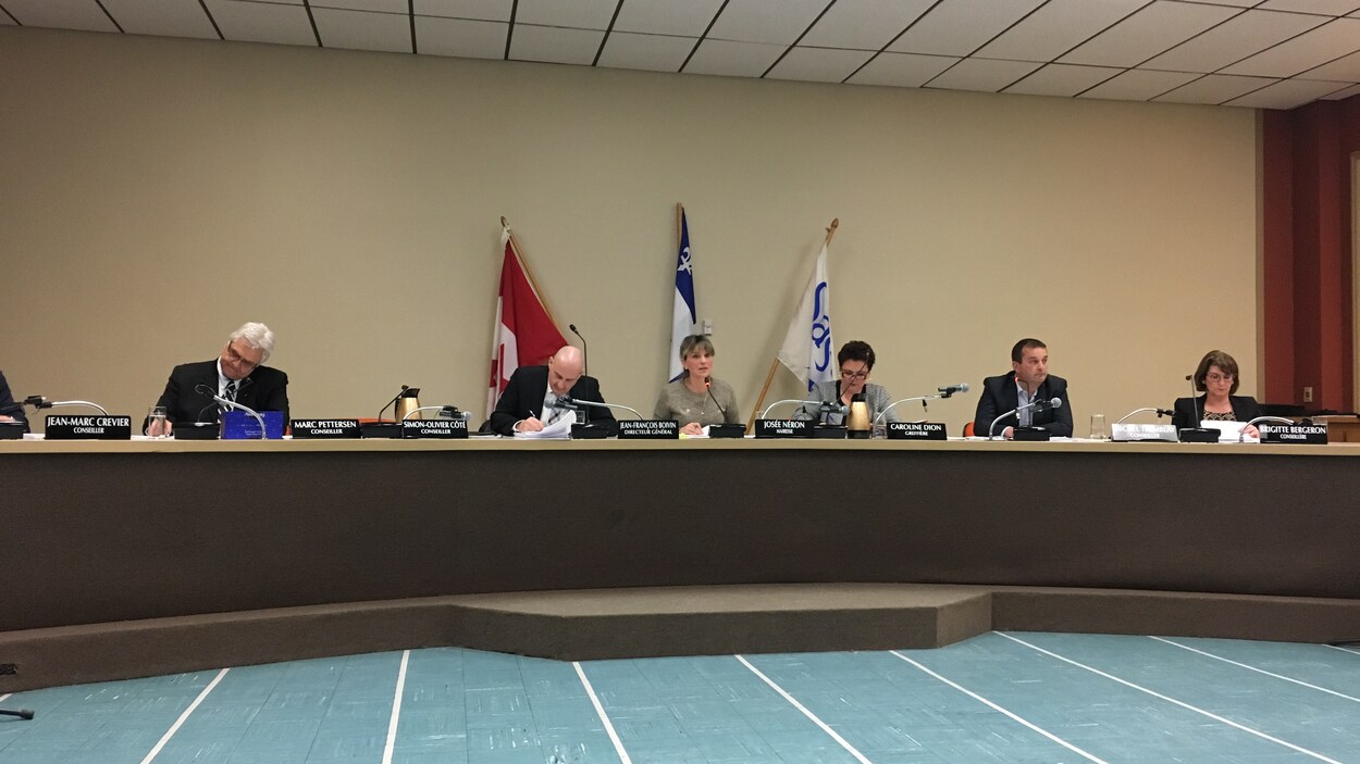 Une table ronde avec plusieurs personnes assises autour de la mairesse qui parle au micro. Une table ronde avec plusieurs personnes assises autour de la mairesse qui parle au micro.
