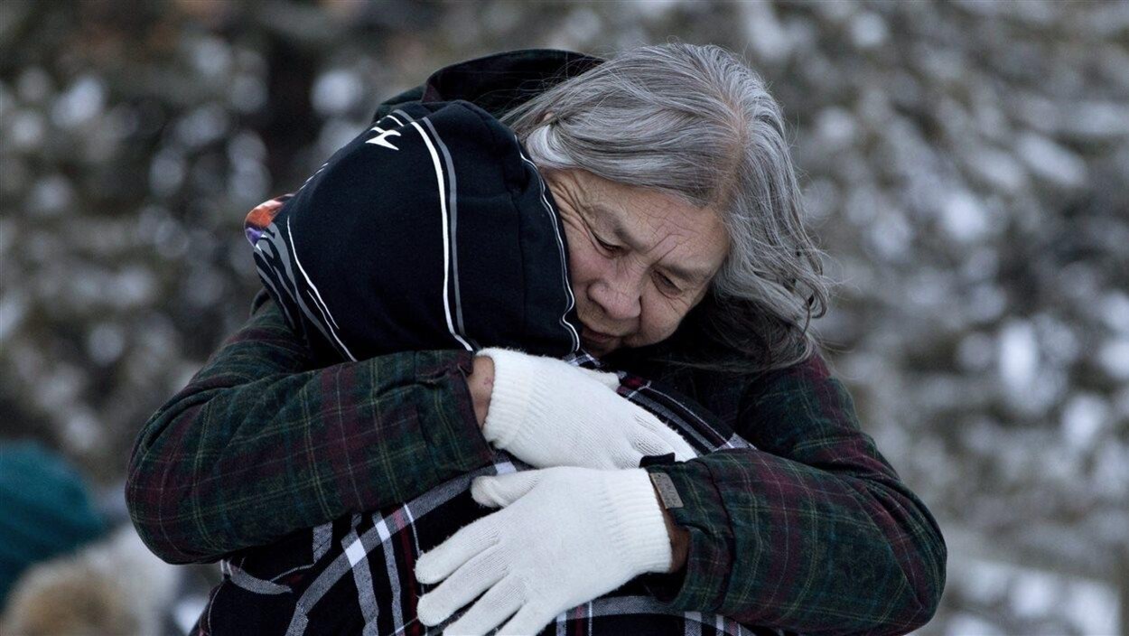 Deux personnes s'étreignent.