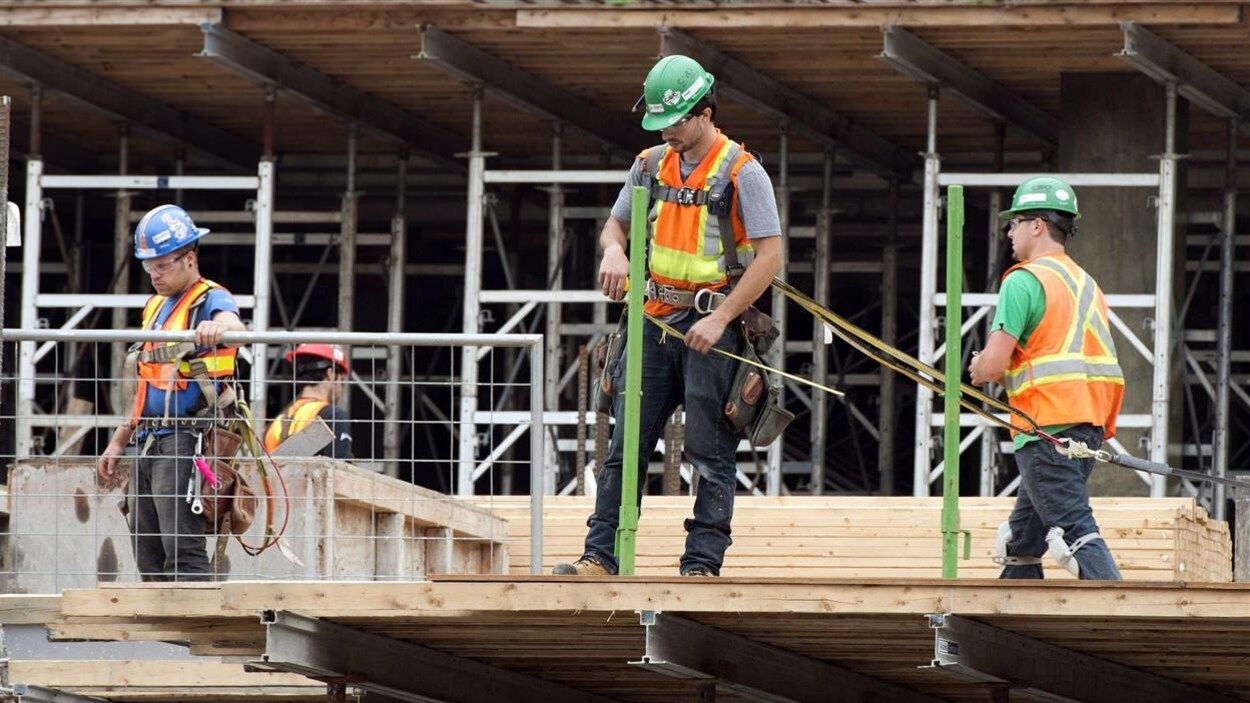 Quatre travailleurs de la construction sur un chantier.