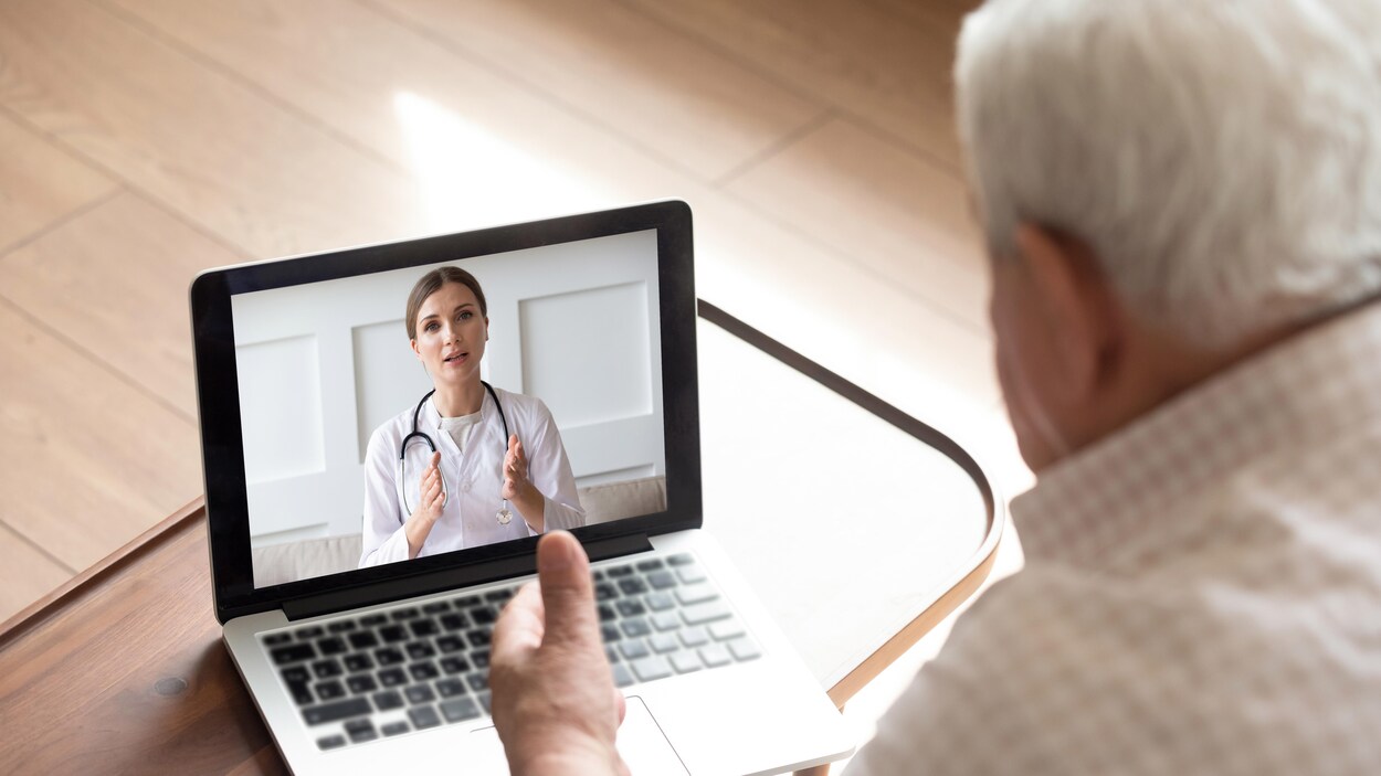 Un homme âgé discute avec une professionnelle de la santé en ligne.