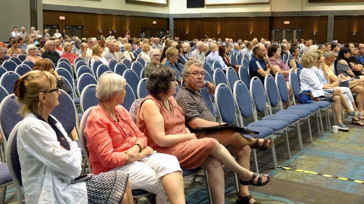 Des résidents sont assis dans une salle de réunion du palais des congrès de Gatineau.
