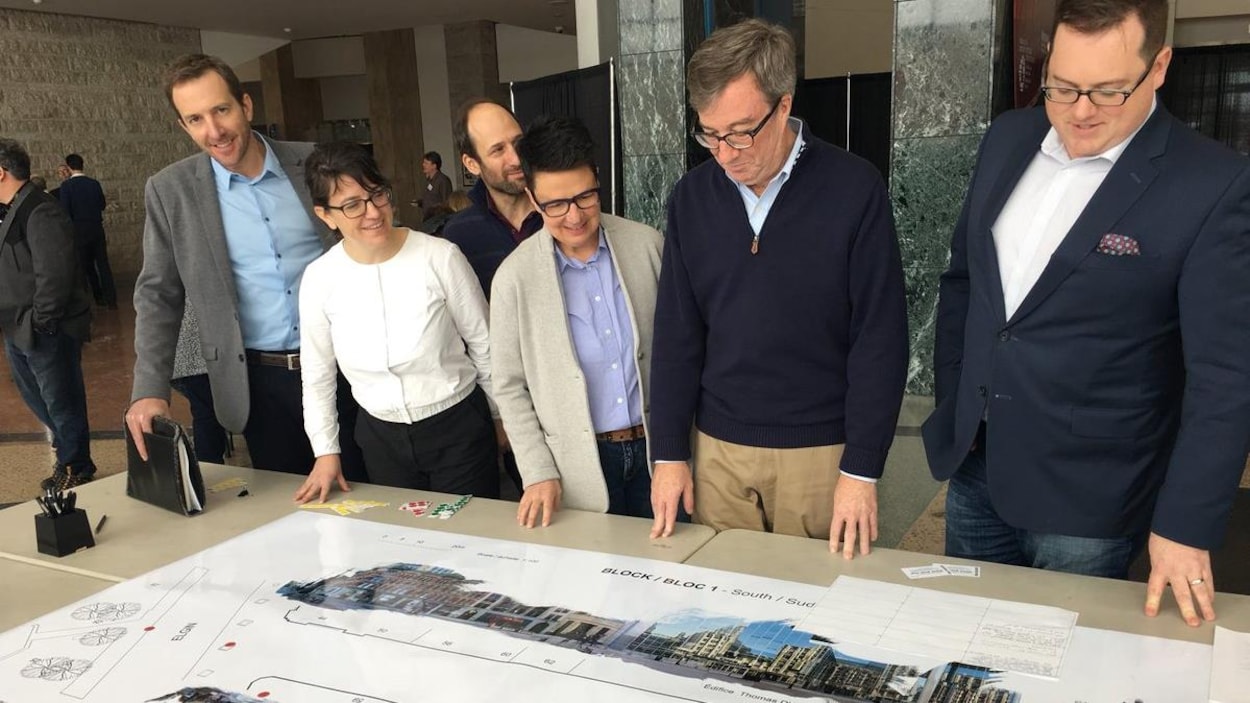 Jim Watson et des conseillers municipaux devant une table où est présenté un plan de la rue Sparks. Jim Watson et des conseillers municipaux devant une table où est présenté un plan de la rue Sparks.